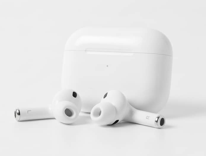 White AirPods Pro 3 earbuds in front of a closed charging case on a light background