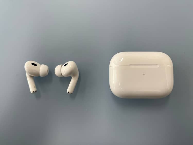 Top-down AirPods Pro 2 earbuds beside a closed horizontal charging case